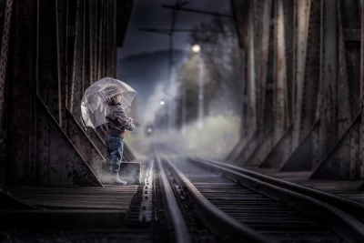 Child with Transparent Umbrella on Misty Railway Bridge Awaiting Train image