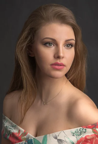 Elegant Young Woman with Thoughtful Gaze and Floral Top Portrait image