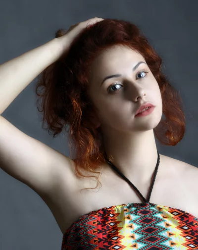 Young Woman with Red Curly Hair Posing in Colorful Ethnic Top image