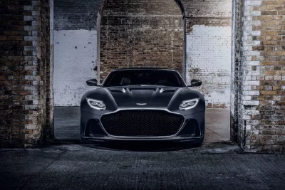 Dark Aston Martin Sports Car Parked in Grungy Garage Cinematic Style Wallpaper HD image