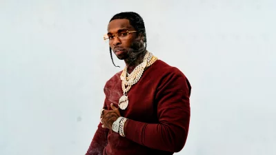 Hip Hop Artist in Maroon Sweater Adorned with Diamond Jewelry and Stylish Glasses image