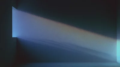 Window light casting a diagonal rainbow spectrum across textured wall