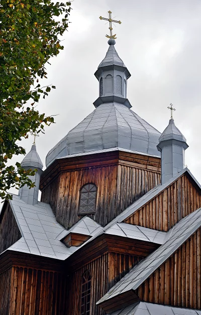 Historic Wooden Church Architecture with Metal Roof and Golden Crosses Against Cloudy Sky image