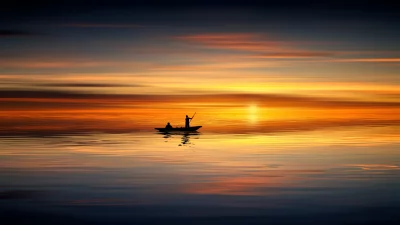 Fishermen Silhouette on Calm Waters at Breathtaking Golden Sunset Reflection image