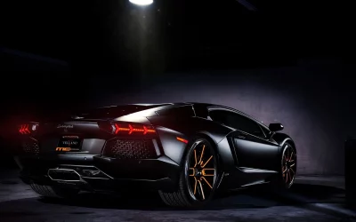 Matte Black Lamborghini Aventador with Striking Orange Rims in a Dark Studio image