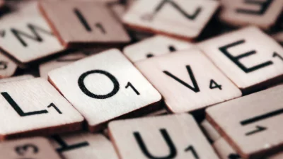 Close-up of Wooden Scrabble Game Tiles Spelling LOVE Word on Textured Background image