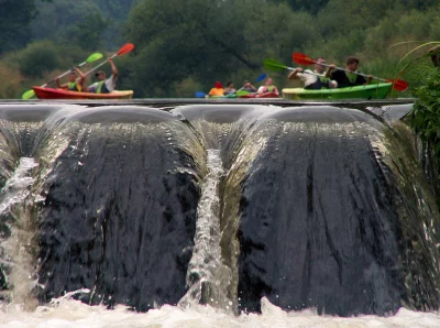 Kayakers Paddling Above a River Waterfall During a Summer Outdoor Adventure image