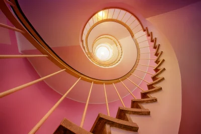 Vibrant Pink Spiral Staircase Ascending Towards Bright Light Modern Architectural Design image