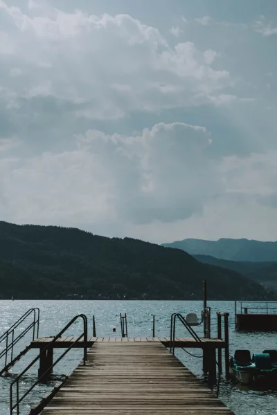 The foreground is dominated by a wooden dock, which is wet from the rain