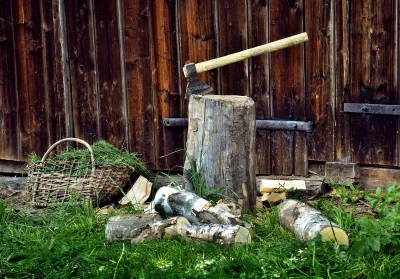 Rustic Axe Embedded in Chopping Block with Wooden Barn Background image