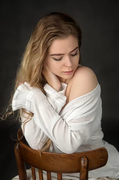 Contemplative Woman with Wavy Blonde Hair in White Off-Shoulder Top image