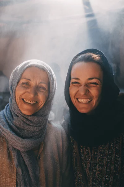 Generational Bond: Two Joyful Women in Headscarves Sharing Radiant Smiles