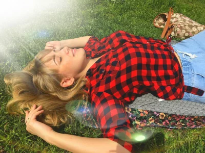 Young Woman Relaxing on the Grass Under the Sunlight