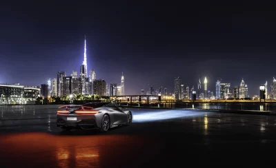 Sleek Luxury Sports Car Illuminates Vibrant Dubai City Skyline at Night image