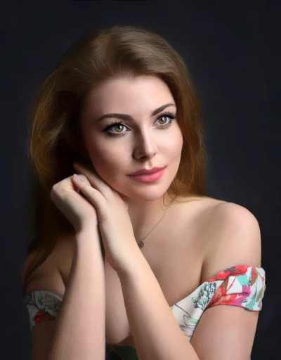 Pensive Young Woman in Off-Shoulder Floral Dress with Green Eyes image