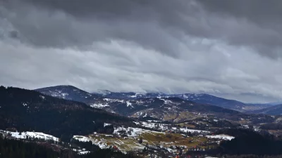 Cloud-Covered Mountains with Patches of Snow and Scattered Settlements image