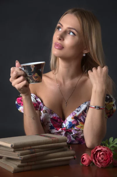 Blonde Woman in Floral Dress Savoring Tea, Contemplative Gaze Portrait image