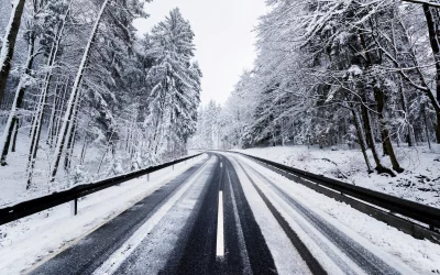 Quiet Winter Road Winding Through a Snow-Covered Pine Forest Landscape image
