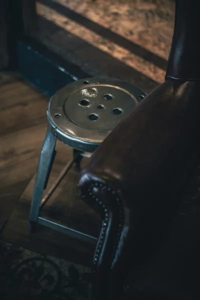 Vintage industrial stool next to a leather chair