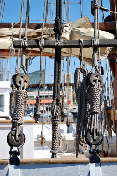 Intricate Ropes and Wooden Pulleys on a Classic Sailboat's Rigging image