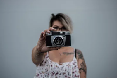 The woman is holding the camera in front of her face