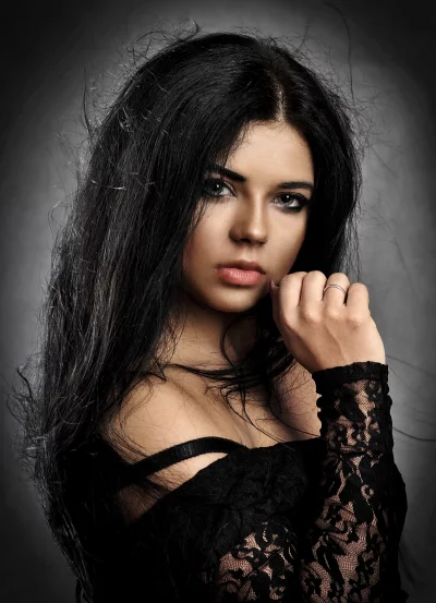 Sultry studio portrait of a woman with long dark hair and elegant black lace image
