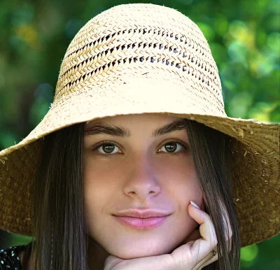 Beautiful Young Woman in Straw Hat Posing with Hand on Chin image