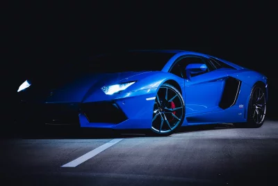 Sleek Blue Lamborghini Aventador Sports Car with Headlights in Dark Setting image