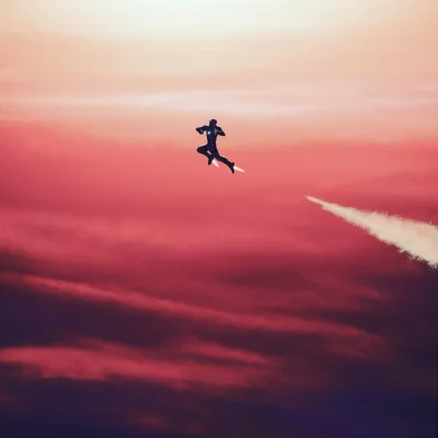 Flying Figure with Glowing Chest and Jet Trails Across Dynamic Sunset Sky image