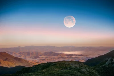 Full Moon Rising Over Misty Mountain Landscape at Twilight image