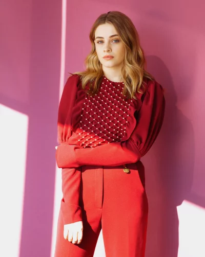 Young Woman Posing in Red Blouse and Trousers with Pearl Accents image