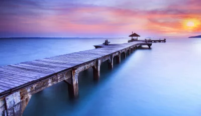 Tranquil Wooden Pier over Ocean with Colorful Sunset Sky image
