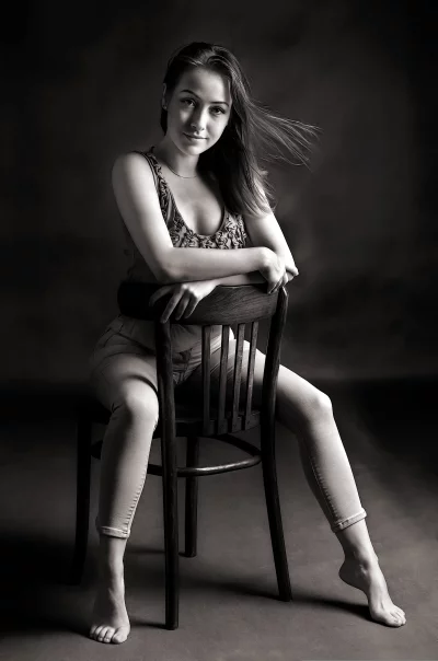 Monochrome Seated Portrait of Woman with Windswept Hair and Elegant Pose image