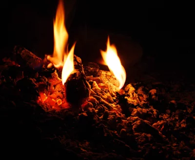 Vibrant Glowing Embers and Flames Illuminating a Dark Background with Intense Heat image