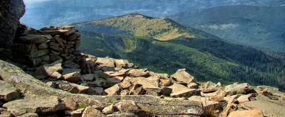 Rugged Mountainous Landscape with Rocky Foreground and Lush Green Forests image