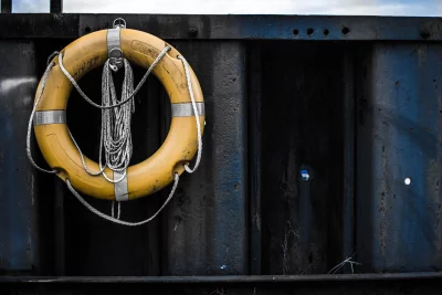 Lifebuoy is hanging on a rusty metal wall