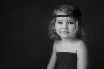 Adorable Little Girl with Feather Headband in Classic Black and White Studio Shot image