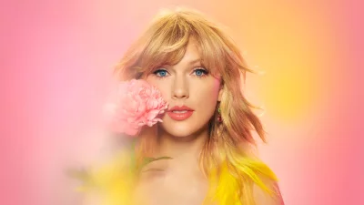 Beautiful Young Woman with Blonde Hair and Blue Eyes Holding a Pink Peony Flower image