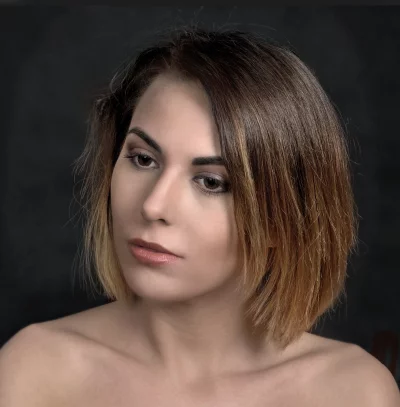 Pensive Young Woman with Ombre Hair and Contemplative Gaze Portrait on Dark Background image