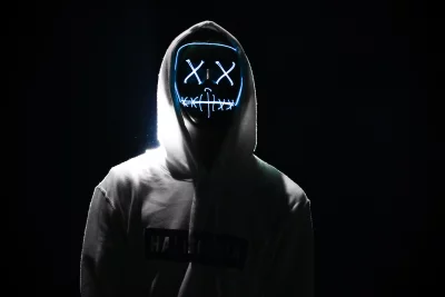 Mysterious Person Wearing Glowing Blue Purge-Style Mask in Dark Setting image