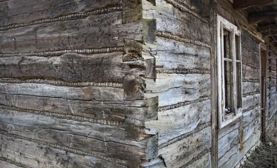 Rustic Weathered Wooden Log Cabin Corner with Traditional Chinking and Old Window Frame image
