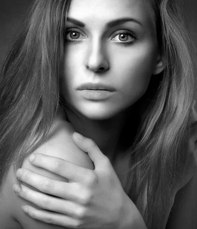 Captivating Black and White Portrait of a Pensive Young Woman with Dramatic Lighting image