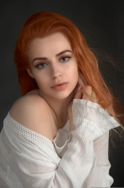 Captivating Redhead Woman with Blue-Green Eyes and Off-Shoulder Top image