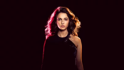 Striking Portrait of Young Woman with Wavy Hair and Dynamic Red-Orange Backlight image