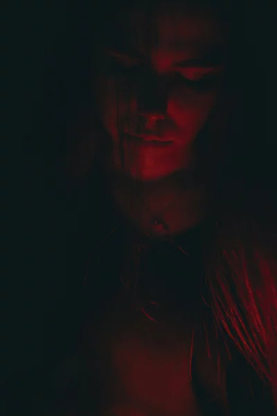 Mesmerizing female portrait illuminated by vibrant red glow and deep shadows 5982