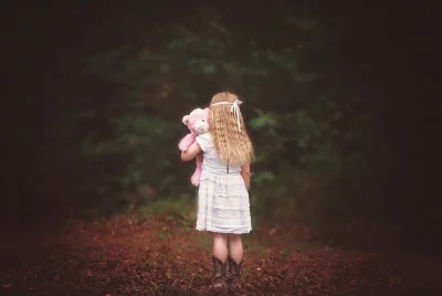 Little Girl Holding Pink Teddy Bear in Enchanted Autumn Forest image