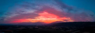 Dramatic Panoramic Sunset Sky Over Alpine Foothills and Rural Fields image