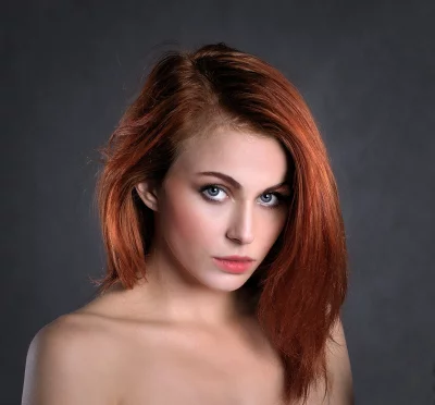 Captivating Young Woman with Fiery Red Hair and Piercing Blue Eyes image