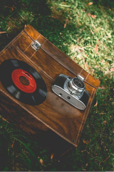 a vintage camera and record player sitting on the grass