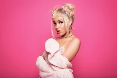 Stylish Blonde Woman with Playful Hair Buns and Pink Roses on Vibrant Background image